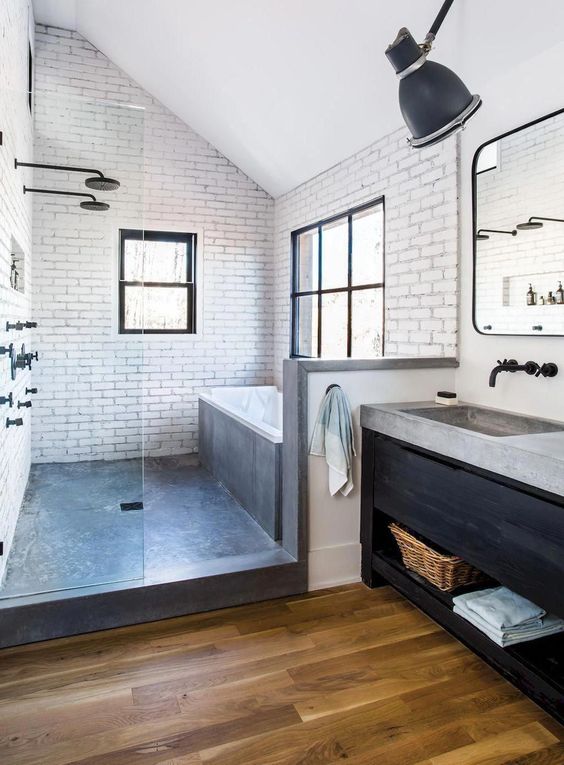 modern industrial bathroom with black vanity and concrete countertop and matte black sink hardware