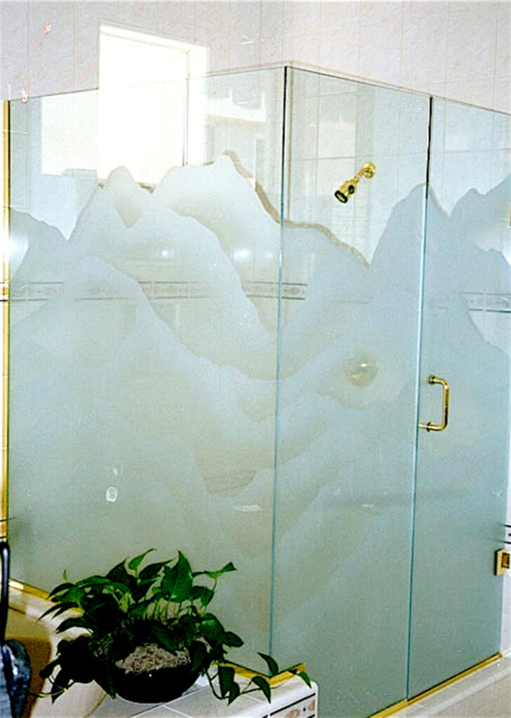 An etched shower enclosure with a mountain scene